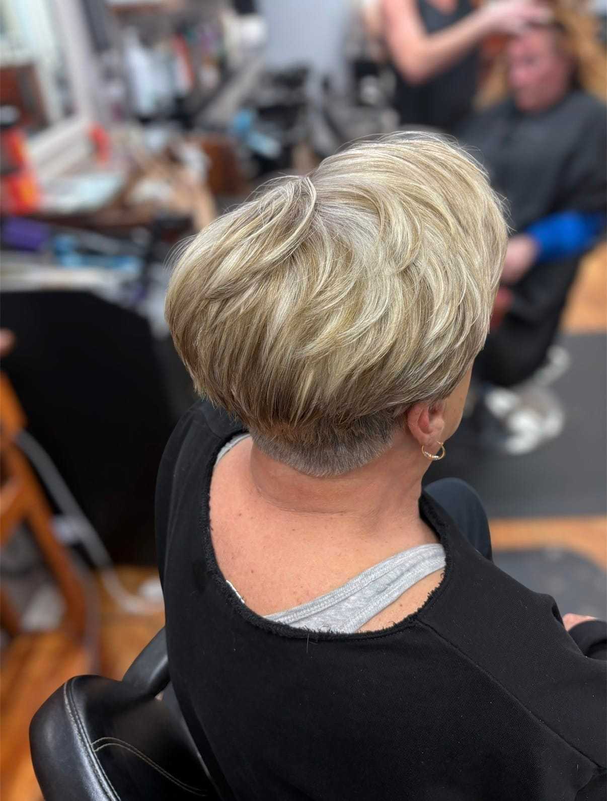 Short blonde hairstyle being styled at a salon.